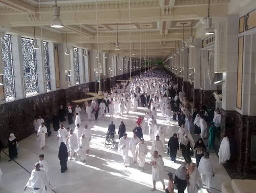 Pilgrims walking the sa'i corridor between Safa and Marwah inside Masjid al-Haram